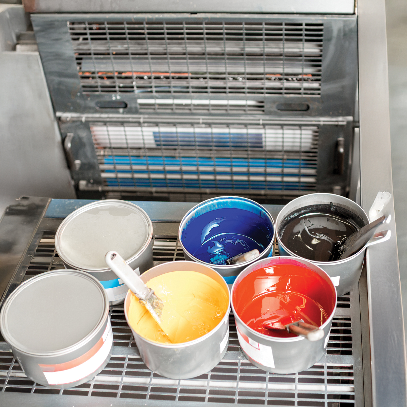 Colour tins on print press shelf